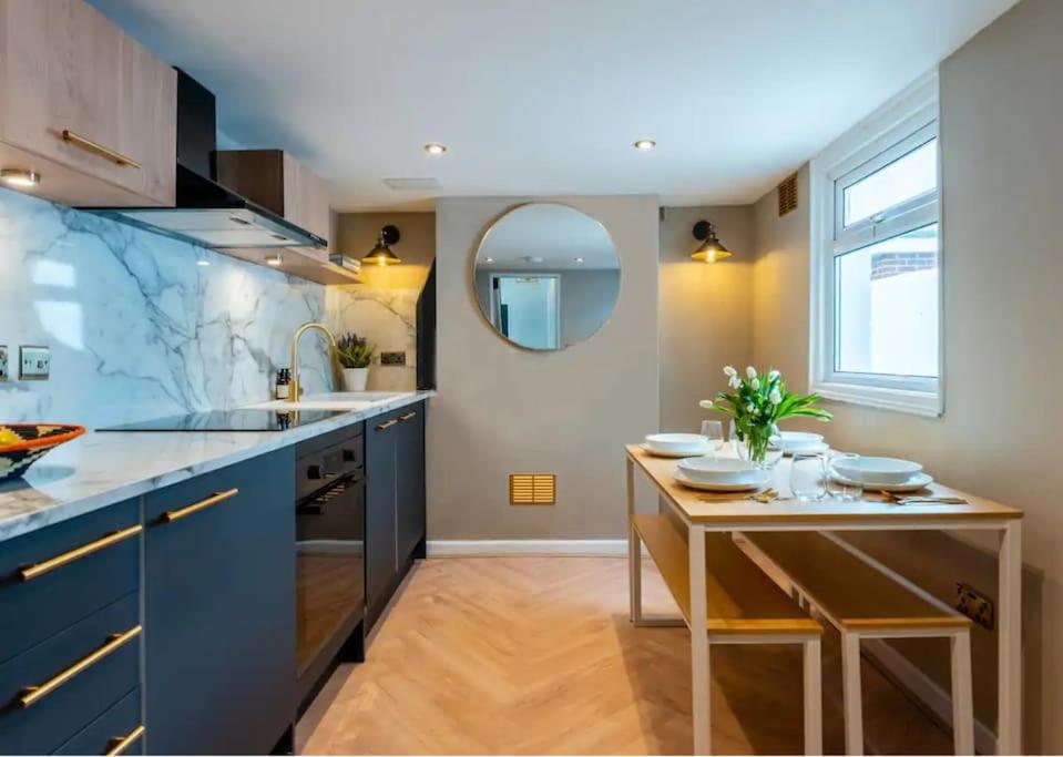 eine Küche mit einem Tisch, einem Waschbecken und einem Spiegel in der Unterkunft Modern & Comfortable Urban Home in Bournemouth