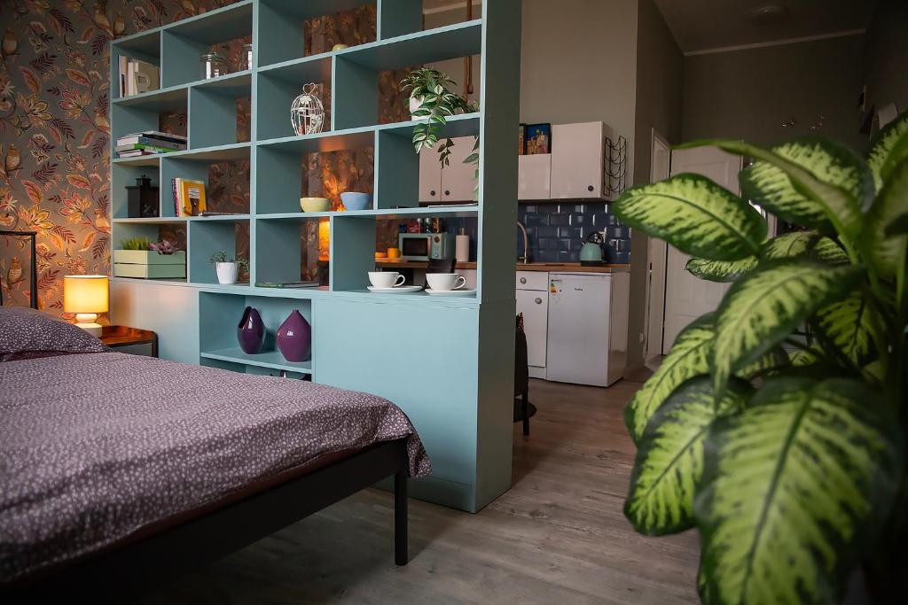 a bedroom with a bed and a blue shelf at Apartament u Olechny 5 in Bydgoszcz