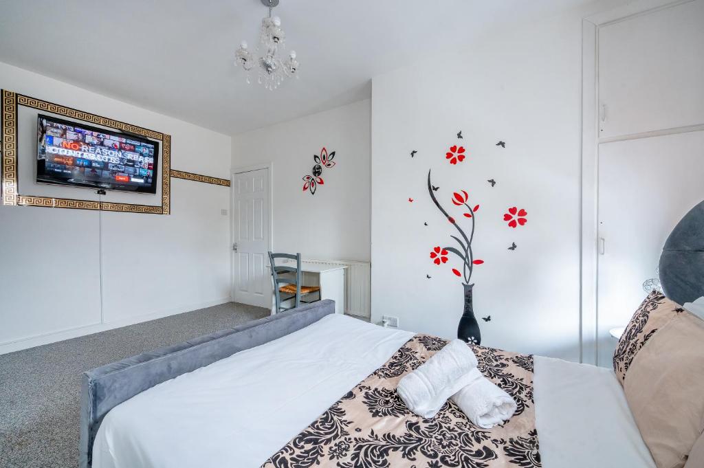 sypialnia z łóżkiem i telewizorem na ścianie w obiekcie *RB60GP* For your most relaxed & Cosy stay + Free Parking + Free Fast WiFi * w mieście Morley