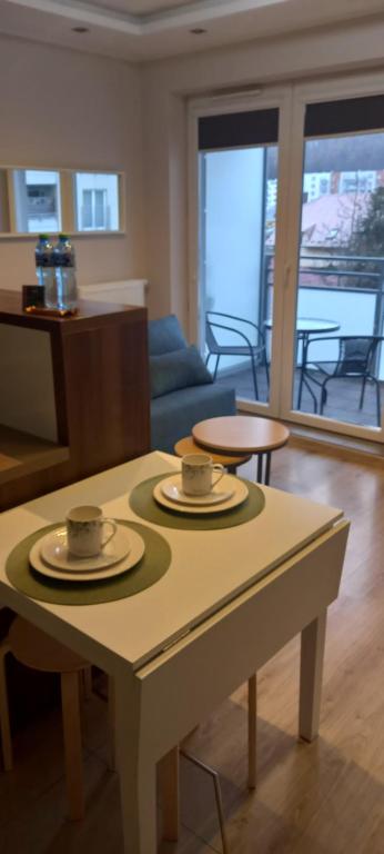 a living room with a table with two cups on it at Apartament morski Aquasfera in Reda