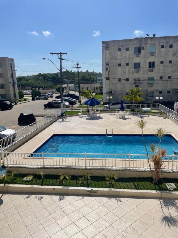 a swimming pool in a parking lot next to a building at Apartamento confortável Ilhéus in Ilhéus
