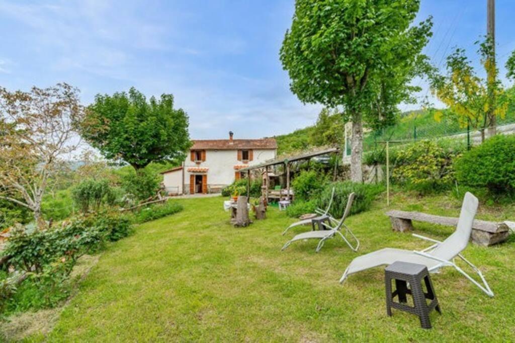 een tuin met stoelen en een huis op de achtergrond bij LA CASINA DI LONNANO in Pratovecchio