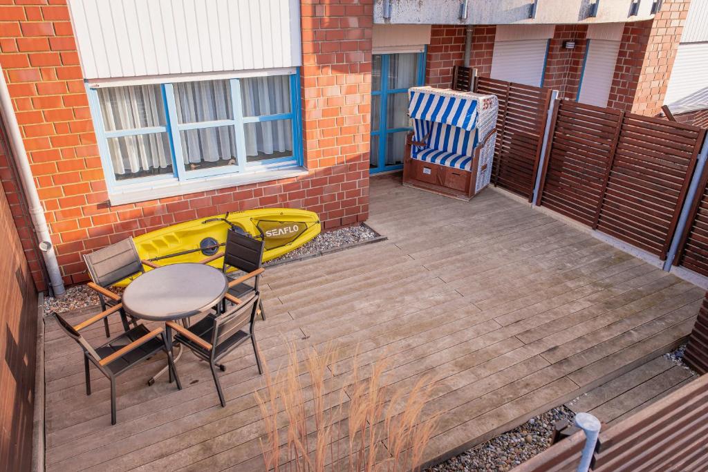 eine Terrasse mit einem Tisch und Stühlen auf einer Terrasse in der Unterkunft Moderne Wohnung mit großer Terrasse in erster Reihe am Deich, Wallbox, Kajak in Schönberger Strand