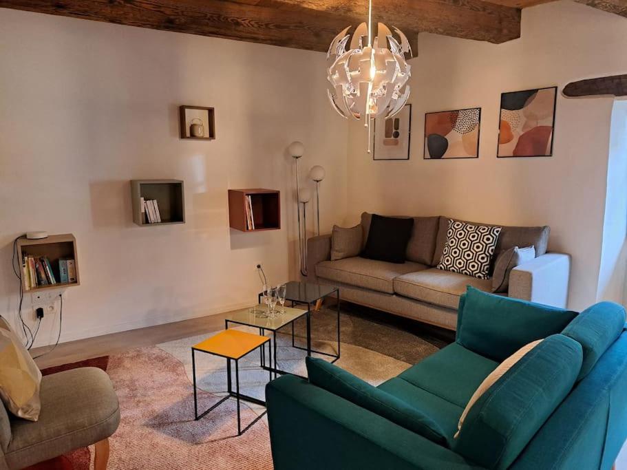 ein Wohnzimmer mit einem Sofa und einem Tisch in der Unterkunft Entre Vignes et vergers Gite Parenthese in Gueberschwihr