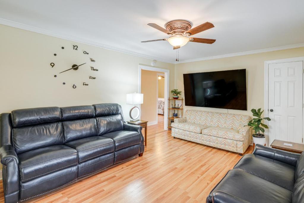 uma sala de estar com um sofá e um relógio na parede em Charming Milton Home with Porch - 5 Mi to VIR! em Milton