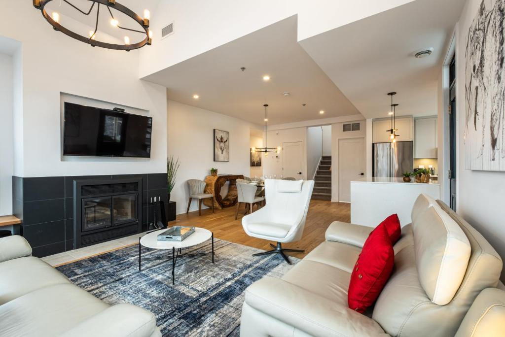 a living room with white furniture and a fireplace at Tremblant Prestige - Les Eaux 215-8 in Mont-Tremblant