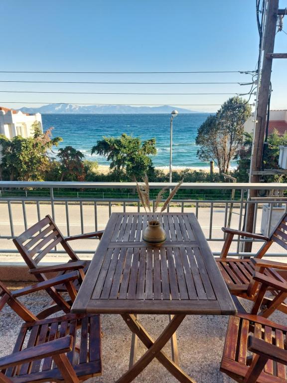 uma mesa de madeira com duas cadeiras e vista para o oceano em Nicola's House - Palio em Kavala