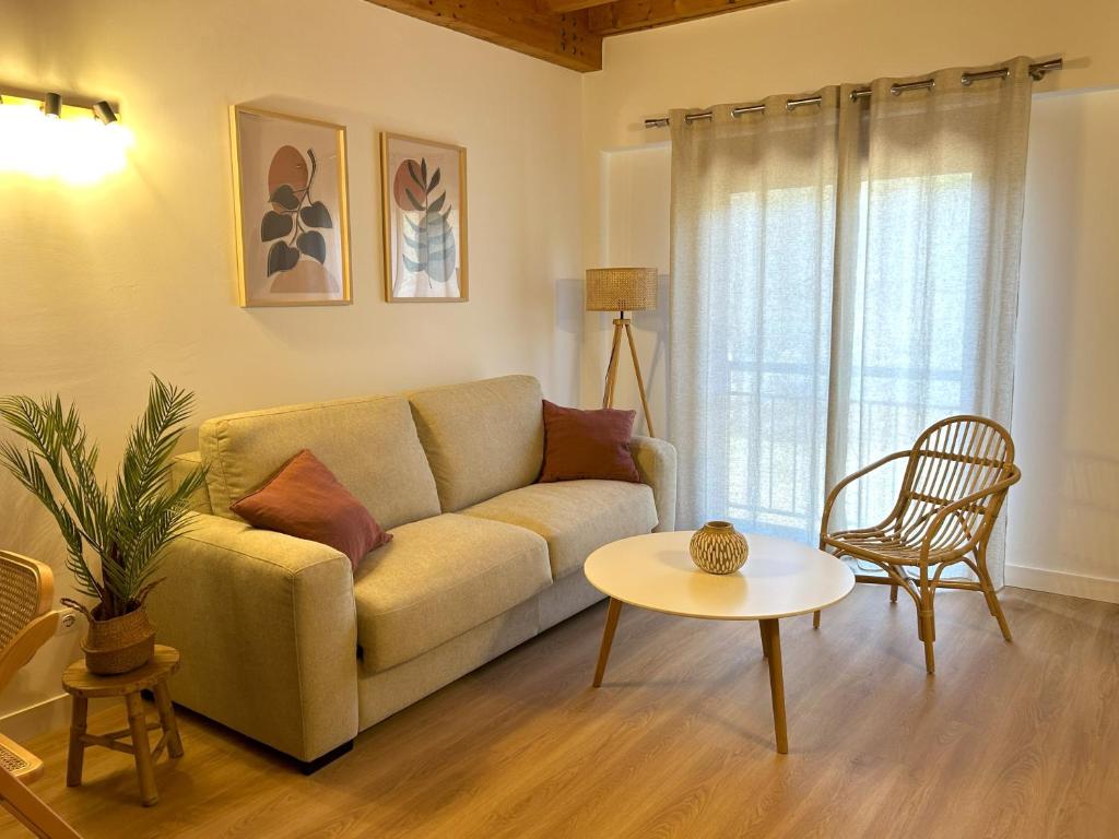 ein Wohnzimmer mit einem Sofa und einem Tisch in der Unterkunft Duplex El Acebuche in Arroyo Frio
