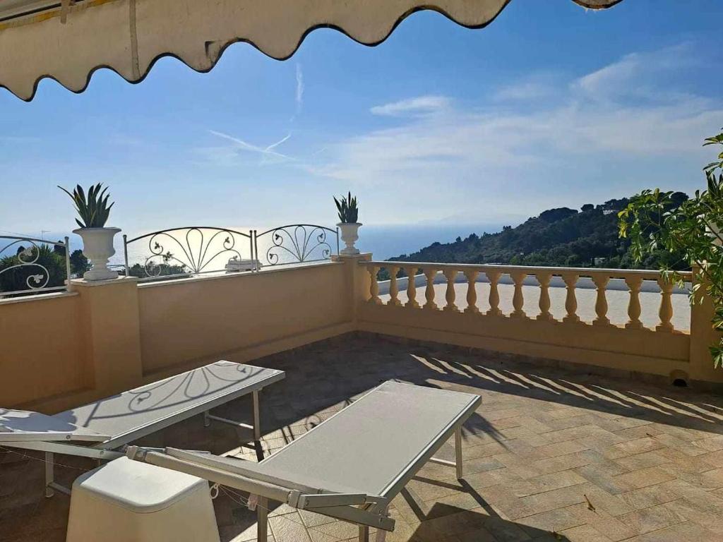 a balcony with two picnic tables on a balcony at Villa Mimosa in Anacapri