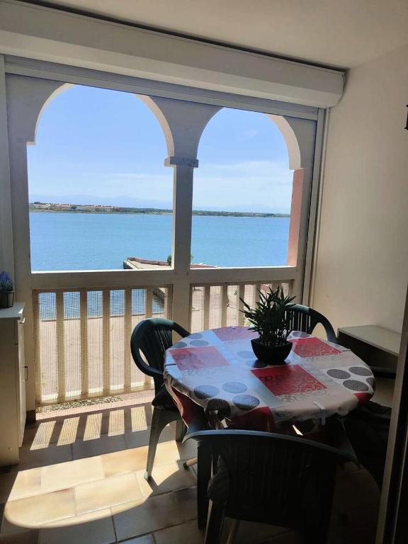 une table et des chaises dans une pièce avec vue sur l'océan dans l'établissement Résidence Pointe Vermeille - Appartement T2 Cabine 6 pers- Les pieds dans l'eau MAE-3984, au Barcarès