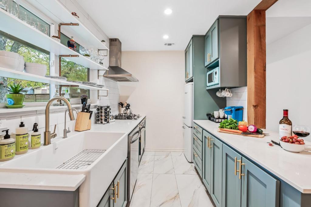 a kitchen with white countertops and blue cabinets at SoCo Oasis Retreat: Relax in Comfort and Style in Austin