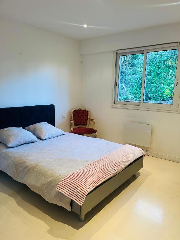 une chambre avec un grand lit et une fenêtre dans l'établissement Villa des Plantes, à Villecresnes