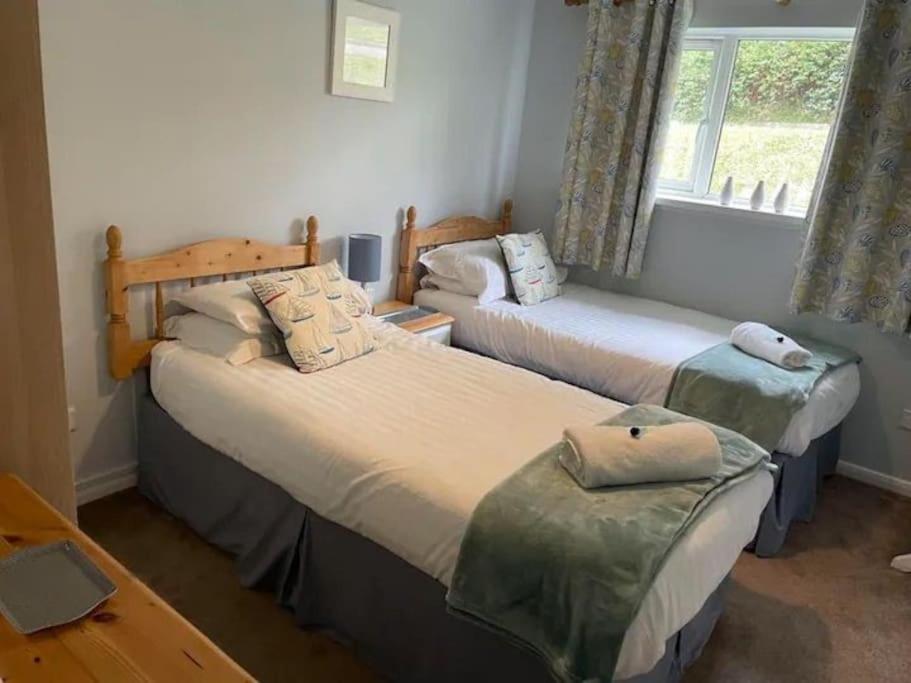 um quarto com 2 camas e uma janela em Manorcombe 19 em Gunnislake