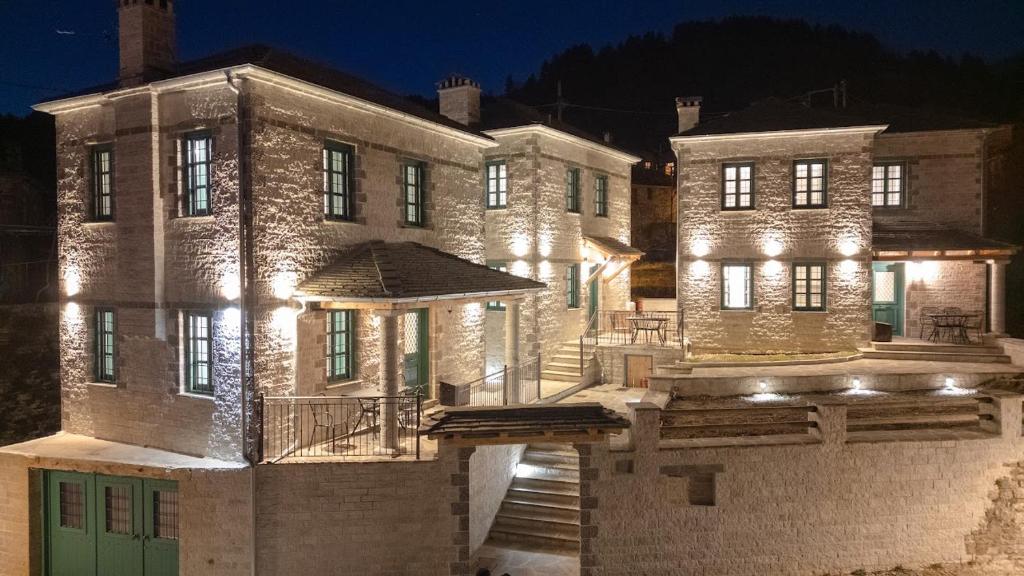 a large brick building with lights on it at night at MAKRIS Papigo Luxury suites in Papigko
