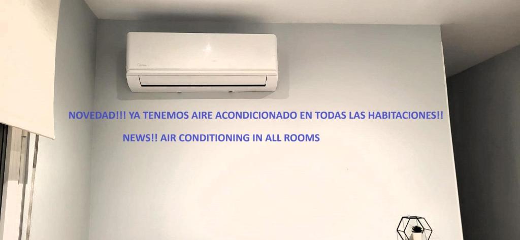 a sign on the wall of a bathroom with a air conditioner at Apt nuevo! 2 hab, baño doble, garaje, Metro a 200m in Madrid