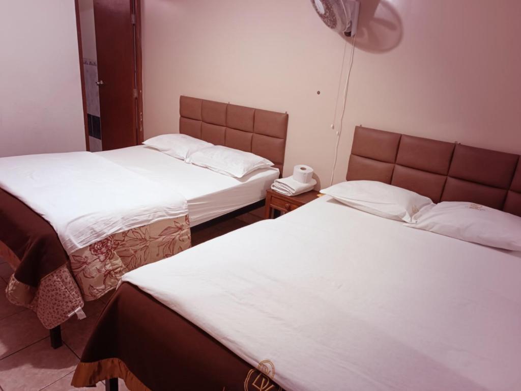una habitación con 2 camas y un teléfono. en Hostal La Dulce Vida, en Trujillo