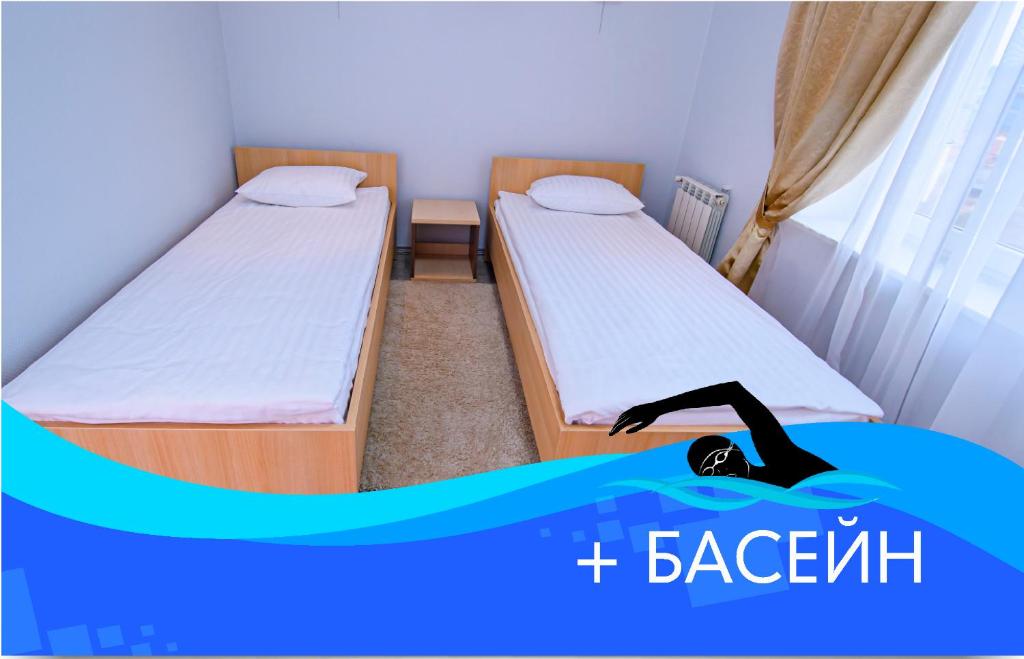 two beds in a room with a person laying on the floor at Olympic Sport in Podgortsy