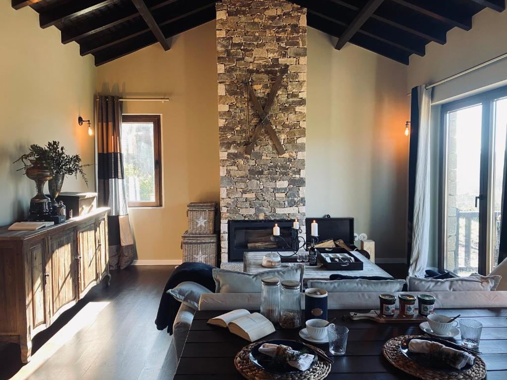 a living room with a couch and a stone wall at Chalé Mezio in Mezio