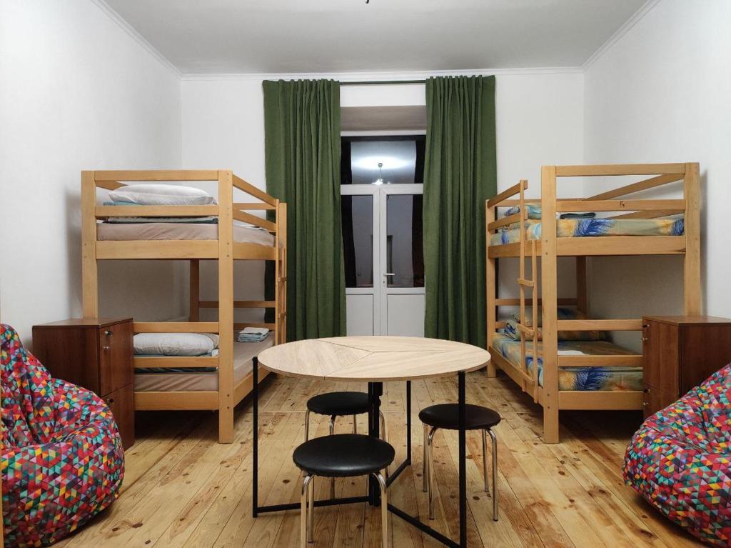a room with bunk beds and a table and chairs at BANDERA Hostel in Lviv