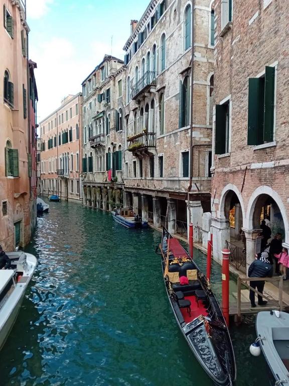 due gondole in un canale tra due edifici di Venice Tourist House a Venezia