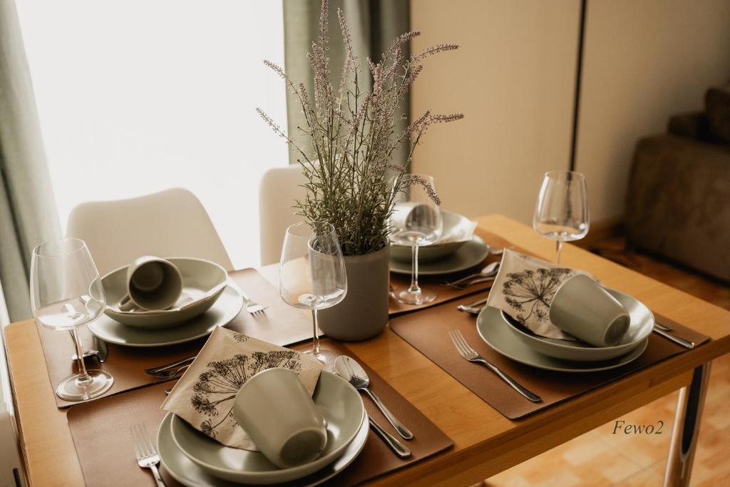 a wooden table with plates and wine glasses on it at Lieblingsplatz by Julia & Tom in Kesselsdorf