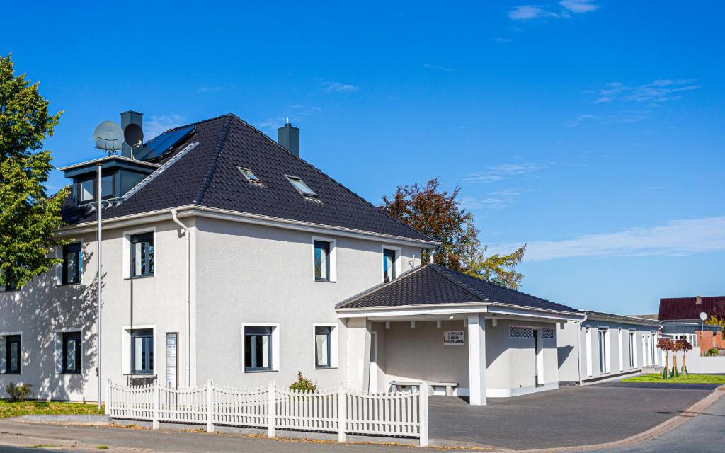 una casa blanca con techo negro en Bellami Ferienwohnungen, en Minden