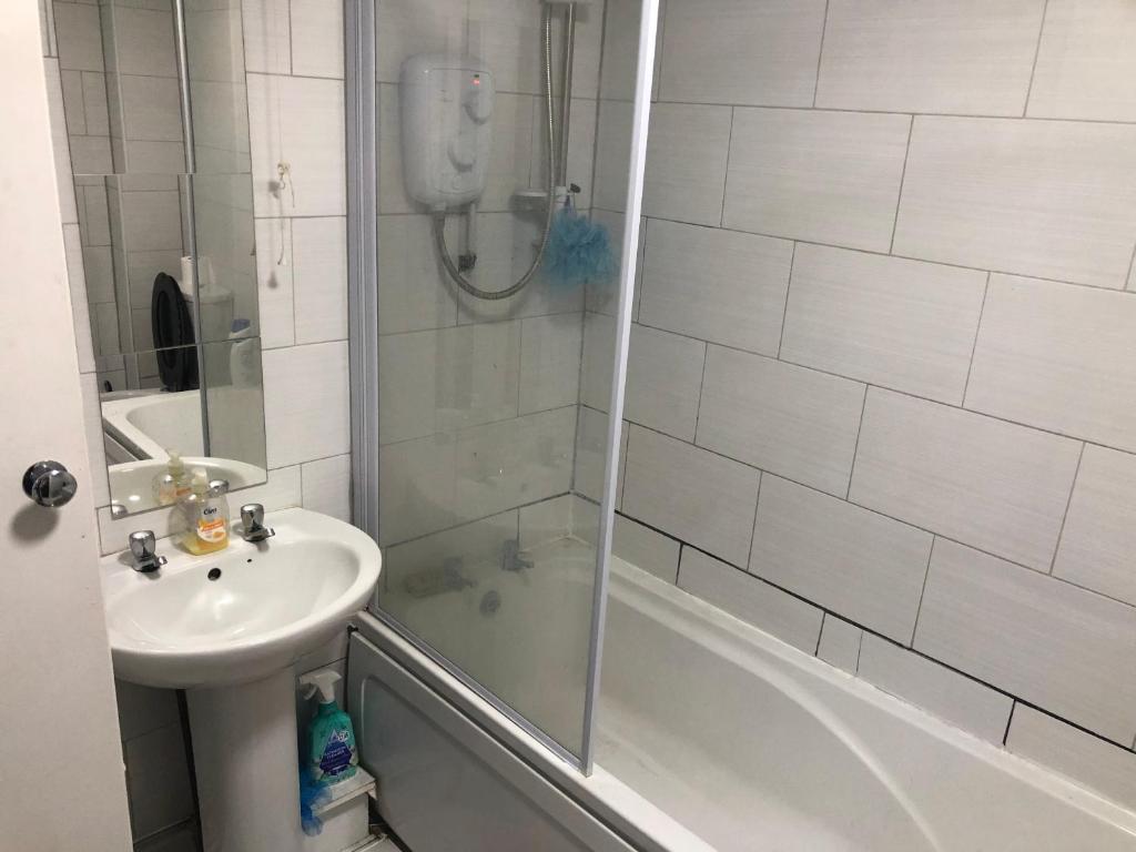 een badkamer met een douche, een wastafel en een bad bij Cozy stanford place in Wolverhampton