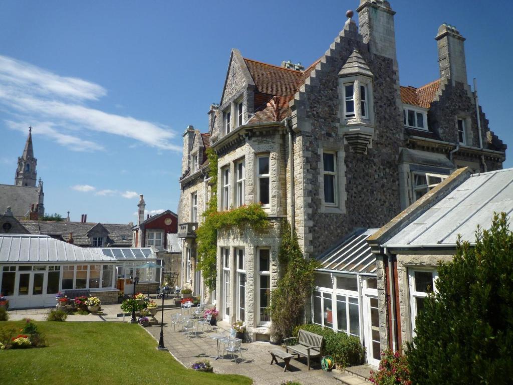 a large building with a courtyard in front of it at Purbeck House Hotel & Louisa Lodge in Swanage