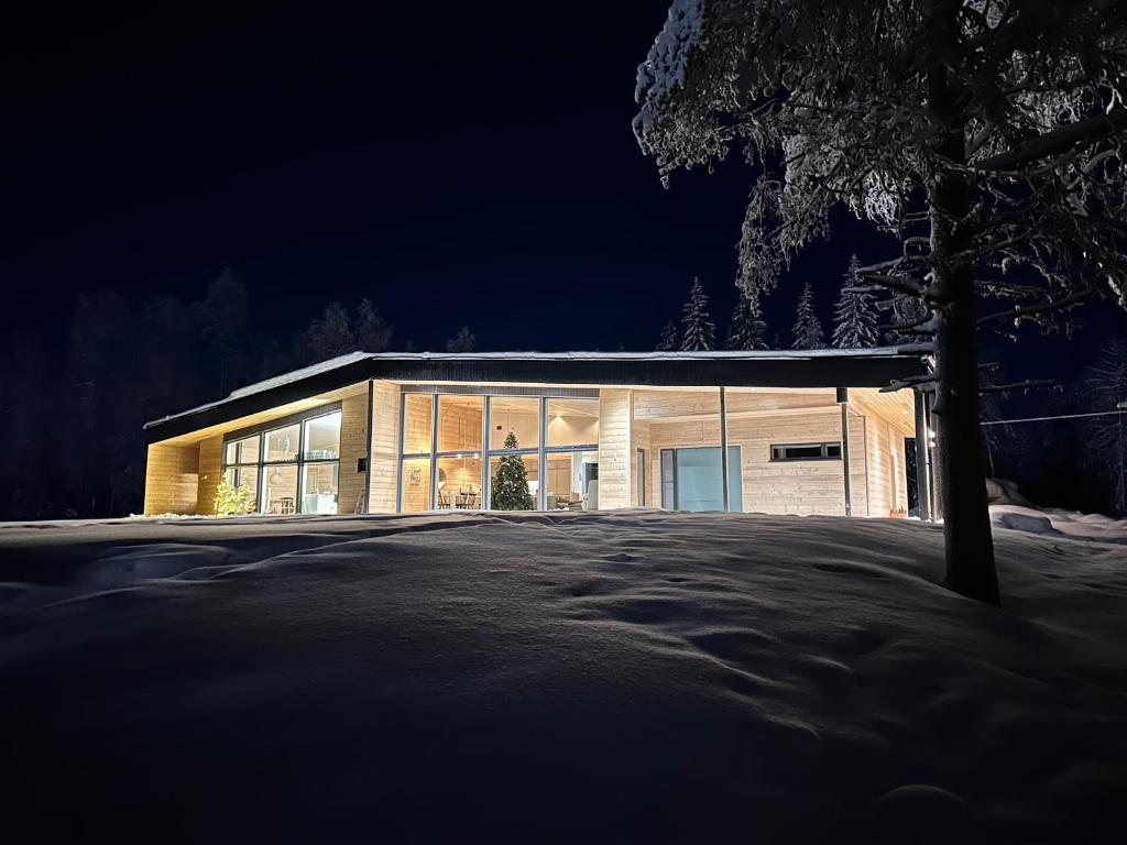 ein großes Gebäude mit großen Fenstern in der Nacht in der Unterkunft Lakeside Lodge Norvis in Rovaniemi