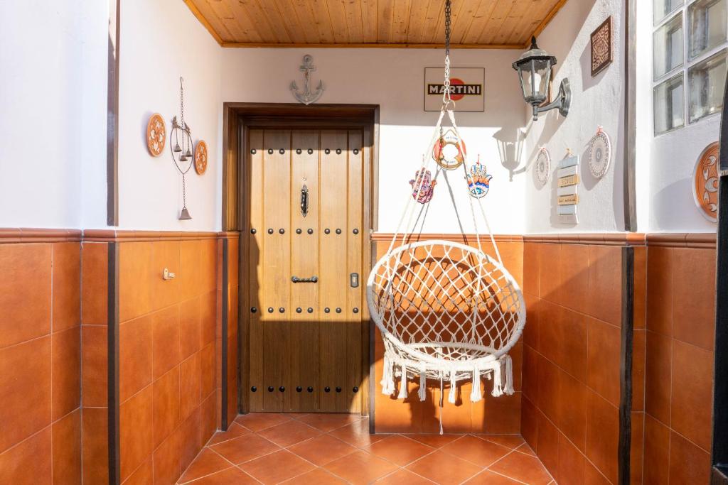 Apartment Aconte Malaga في مالقة: كرسي الخوص في غرفة مع باب