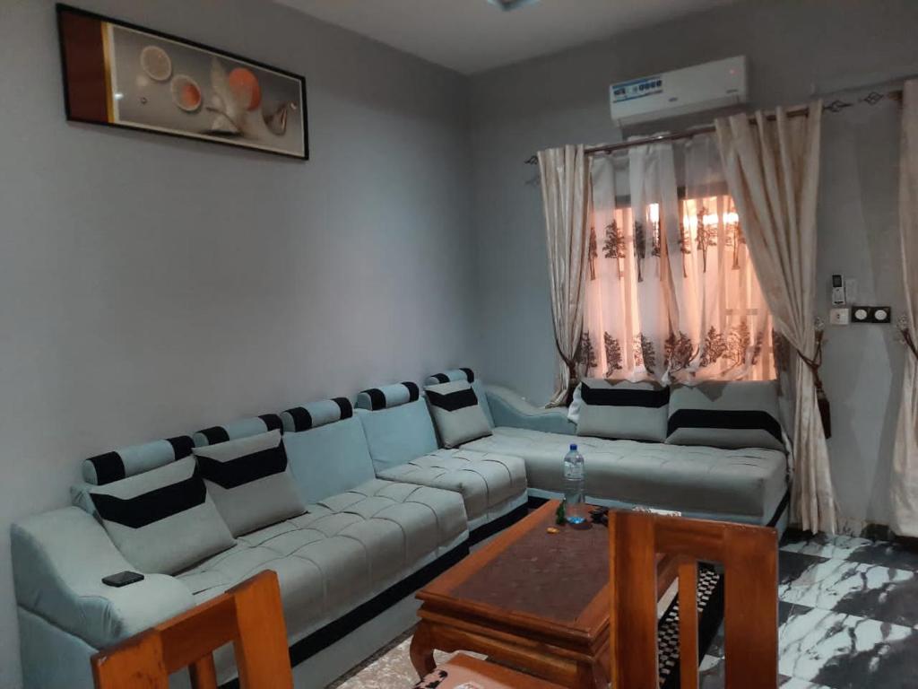 uma sala de estar com um sofá e uma mesa em Résidence kenzaina em Ouagadougou
