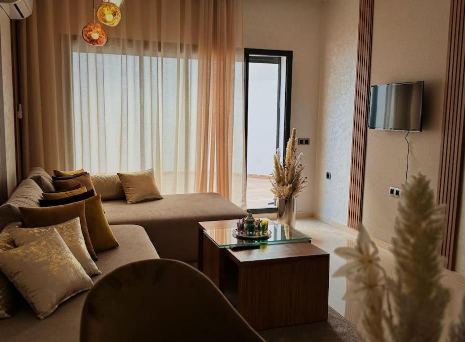 a living room with a couch and a table at Cozy Appart central à terrasse in Casablanca