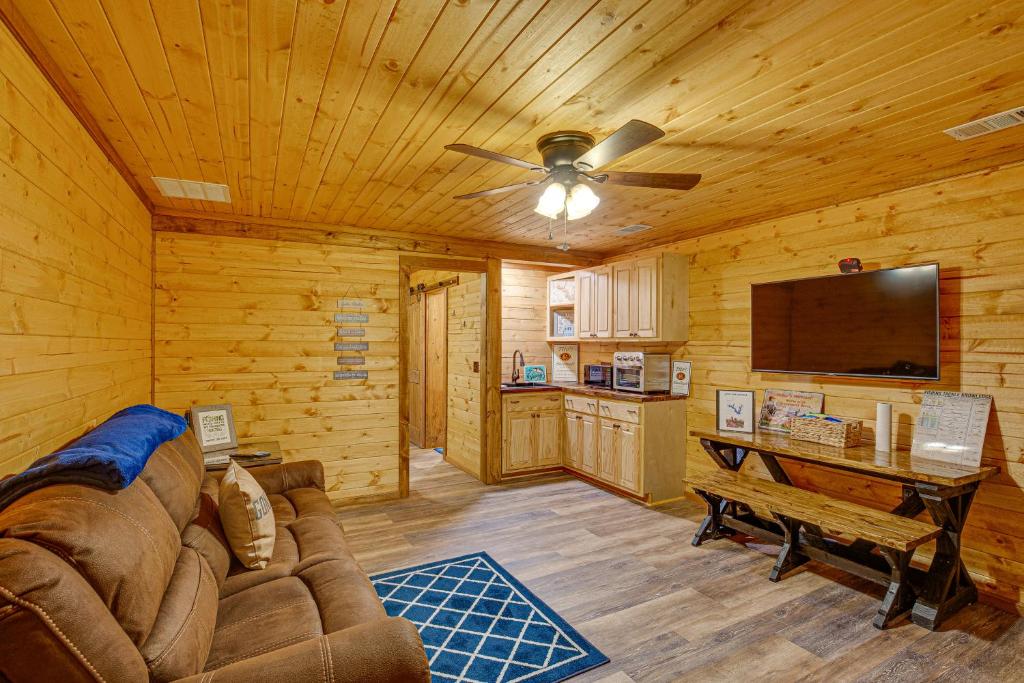 a living room with a couch and a flat screen tv at Cozy Quitman Fishing Cabin Near Lake Fork! in Quitman