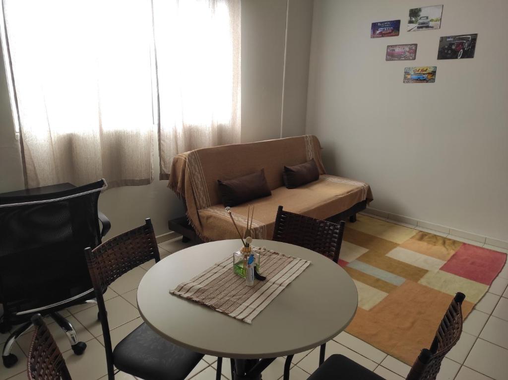 ein Wohnzimmer mit einem Tisch, Stühlen und einem Sofa in der Unterkunft Apartamento inteiro no Alto Umuarama, próximo ao Aeroporto, Medicina e Granja Marileusa. in Uberlândia