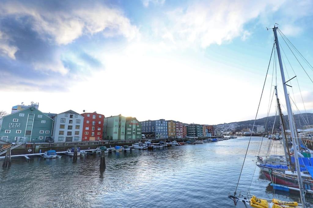 vista para um rio com barcos e edifícios em Budget studio by the city canal em Trondheim