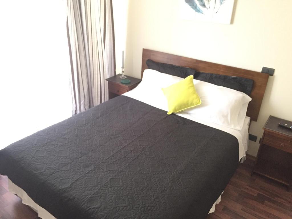 Dormitorio con cama con almohada amarilla en BELLAVISTA DARDIGNAC, en Santiago