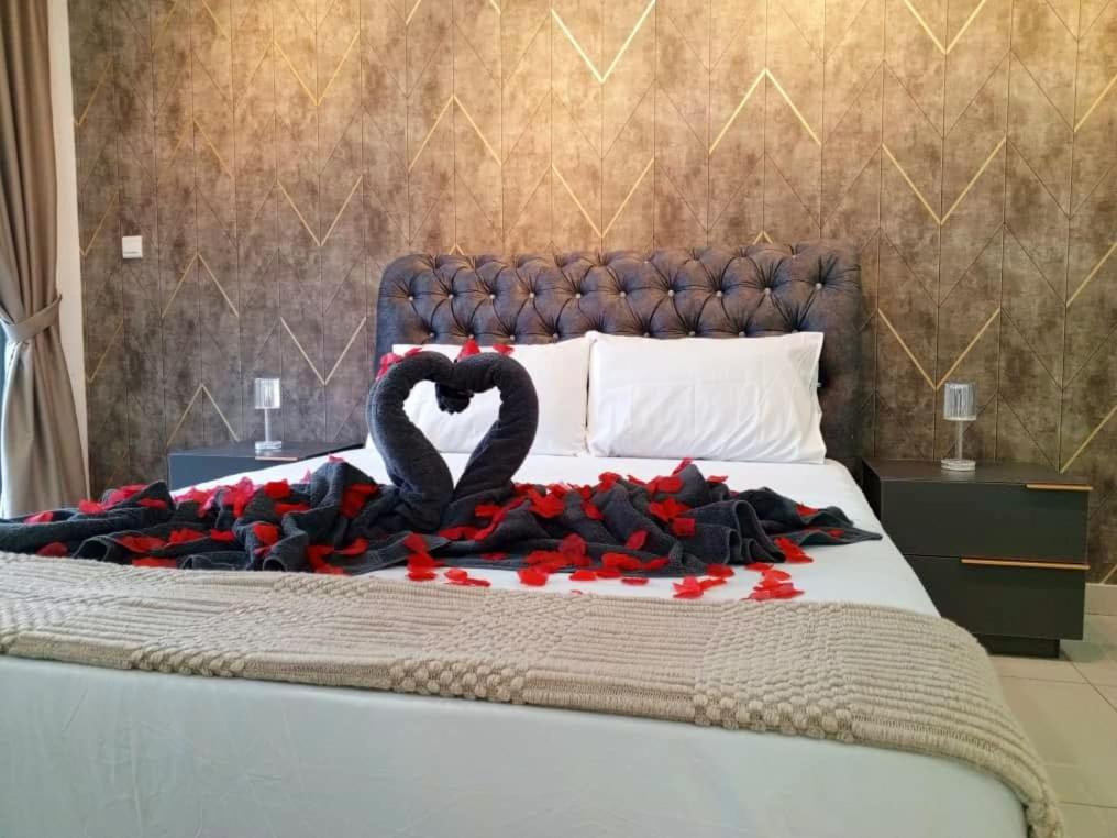 Una cama con un corazón hecho de rosas rojas en Nadayu Studio 舒适环境民宿大阳台适合举办生日会, en Kuala Lumpur