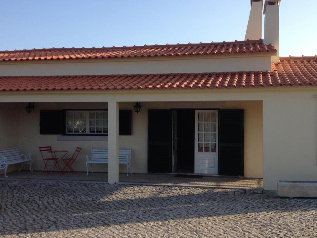 塞圖巴爾的住宿－Casa do Jardim，白色的房子,设有门廊和长凳