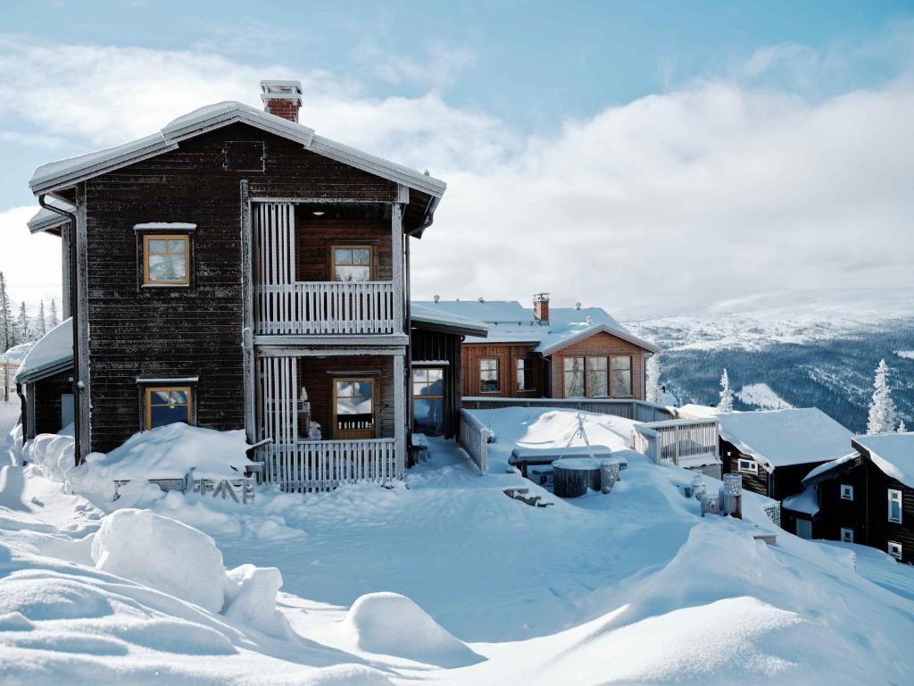 una casa está cubierta de nieve en Åre Valley Lodges - Kopparvillan, en Åre