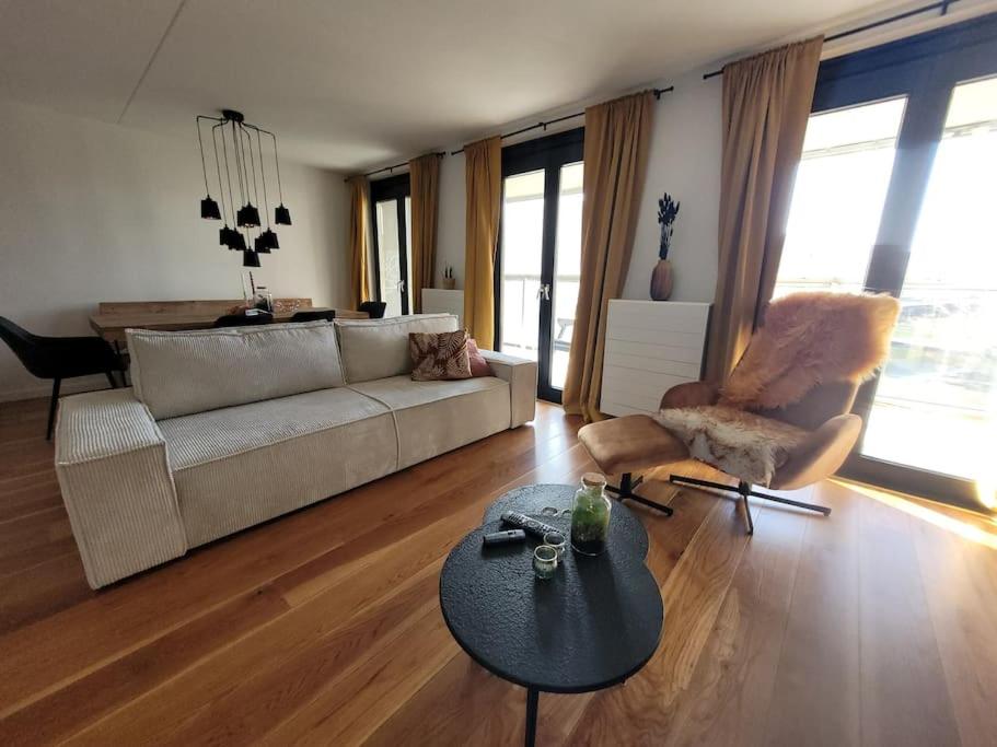 uma sala de estar com um sofá e uma mesa em Alex Place em Utrecht