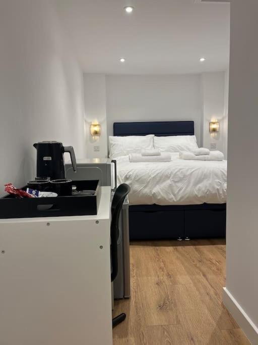 a bedroom with a bed with a coffee maker on a counter at Novanik Studio Apartment in Milton Keynes