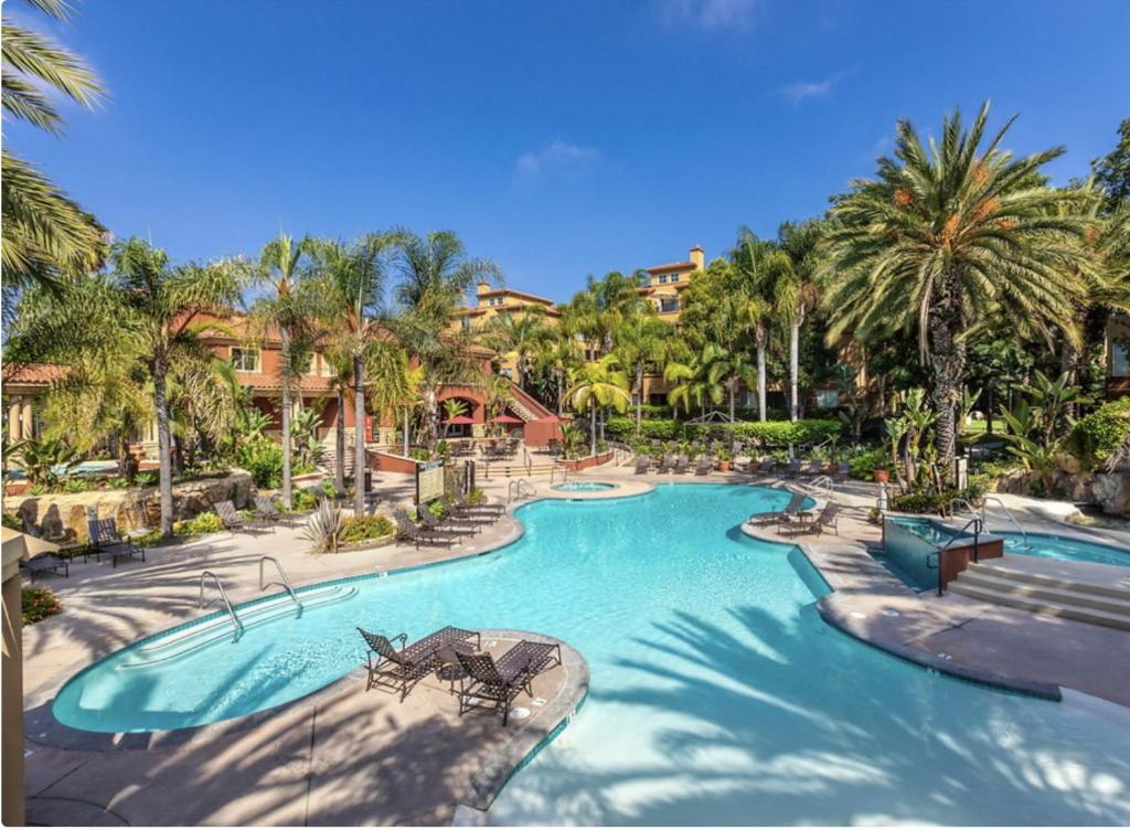 a swimming pool at a resort with palm trees at Lux Playa Vista 2 BDRM Condo in Los Angeles