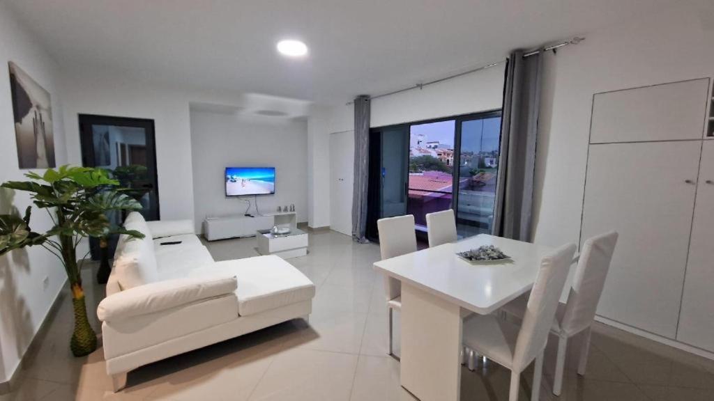 ein Wohnzimmer mit einem weißen Sofa und einem Tisch in der Unterkunft Aparthouse EdHel T2 in Praia