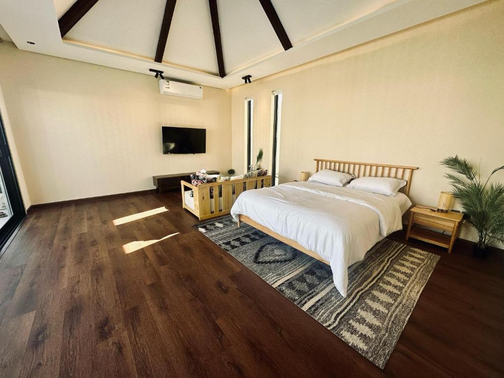 a bedroom with a bed and a tv on a wall at منتجع تربل فور - Triple Four Resort in Buraydah