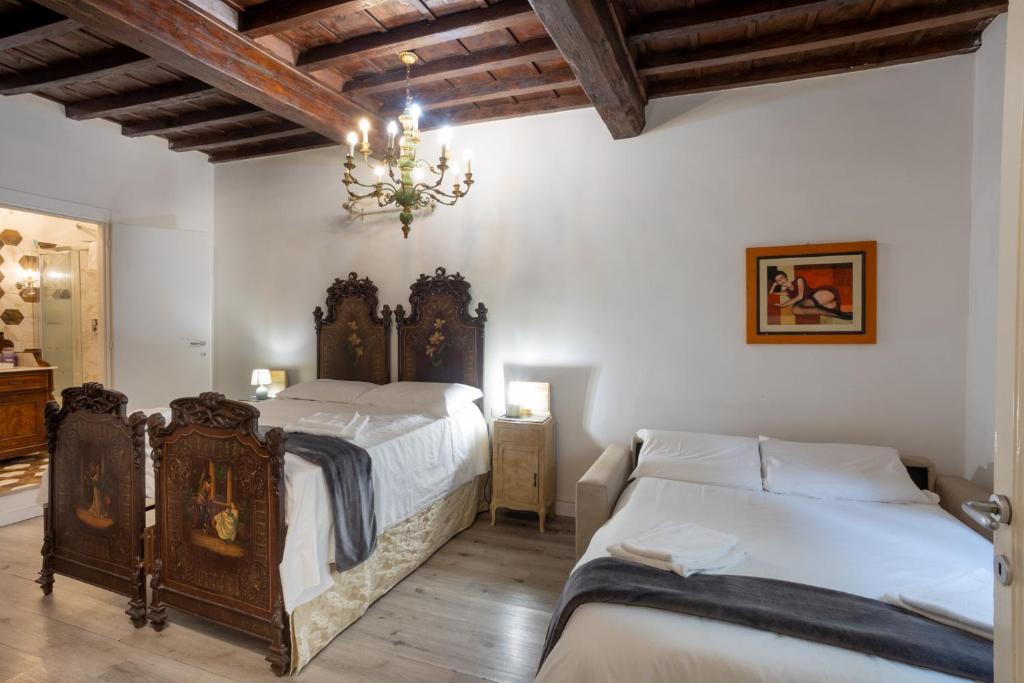 Un dormitorio con dos camas y una lámpara de araña. en Florencia Luxury Apartament, en Florencia