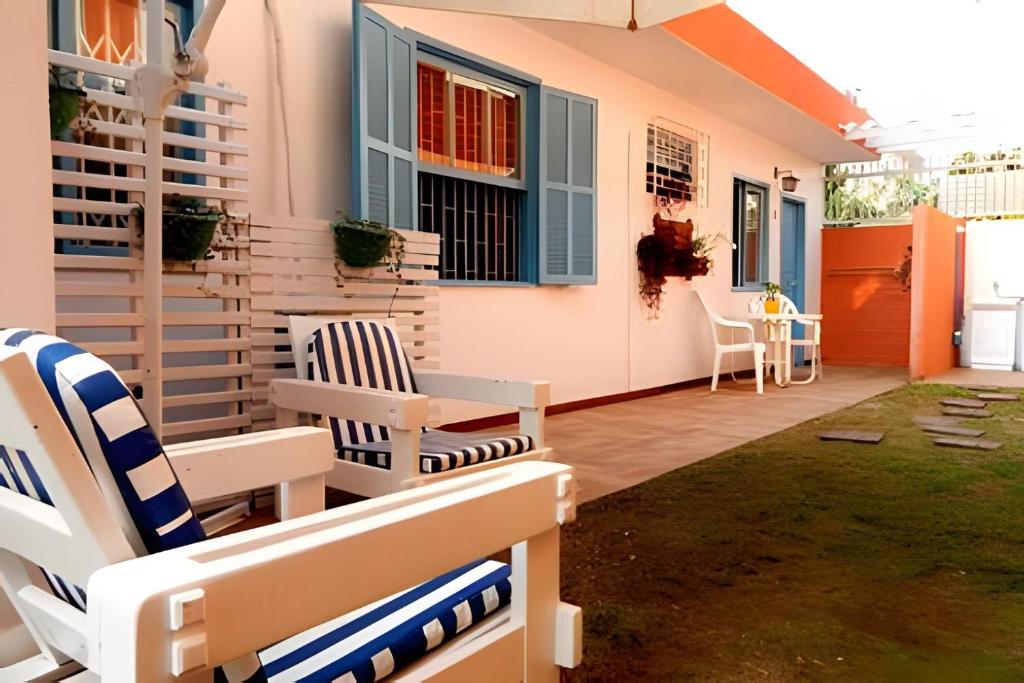 een patio met 2 stoelen en een tafel bij Pouso do Guarani - 200m do mar|wifi|Ar cond in Florianópolis