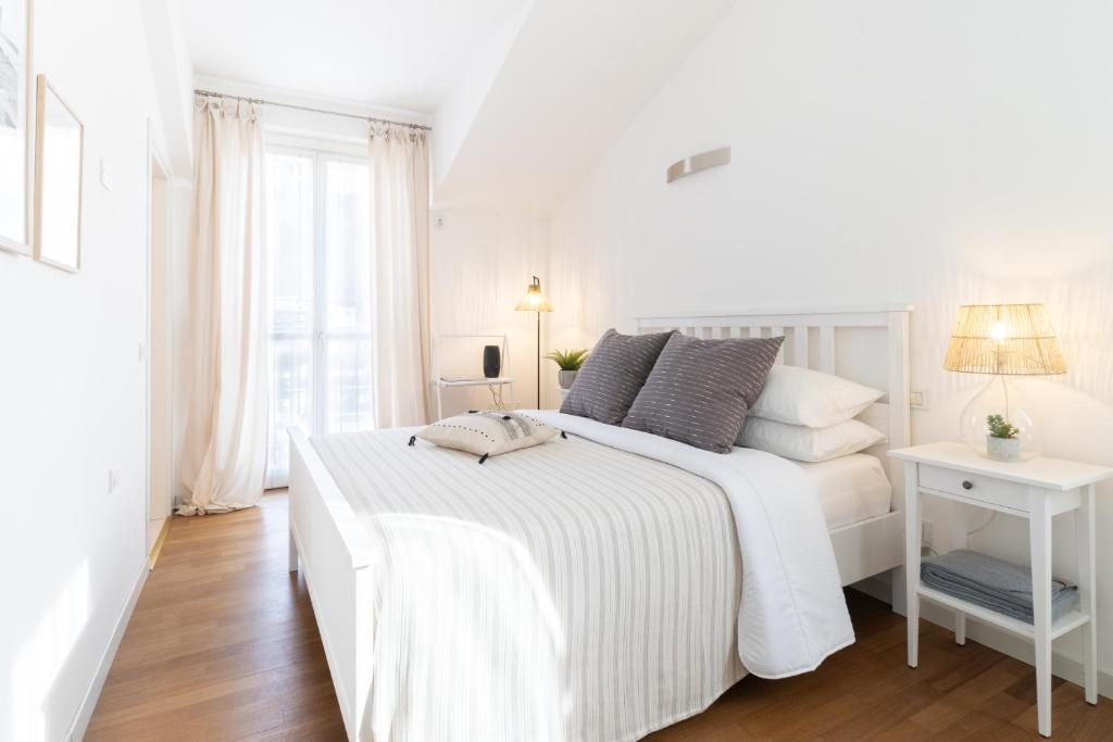 a white bedroom with a white bed and a window at Dream Suite in Como in Como