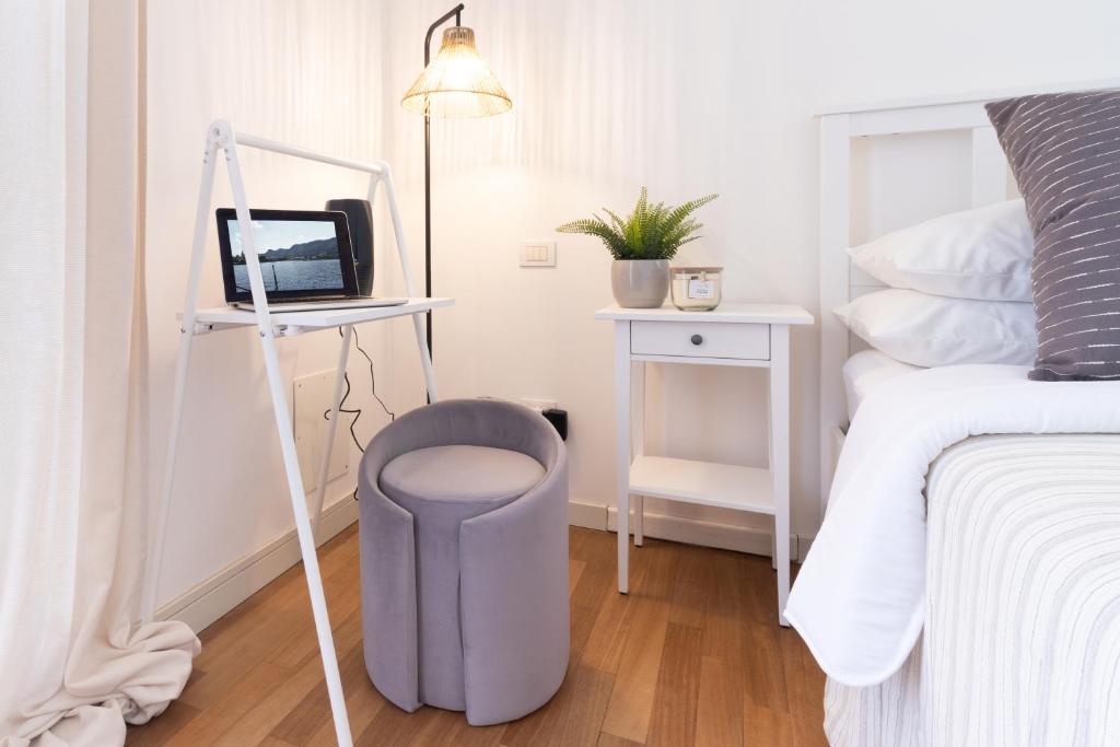a bedroom with a stool next to a bed and a mirror at Dream Suite in Como in Como