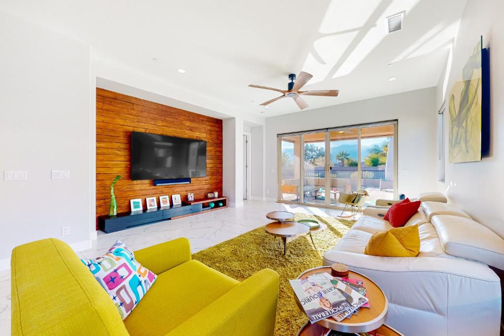 a living room with a white couch and yellow chairs at Desert Cool in Rancho Mirage