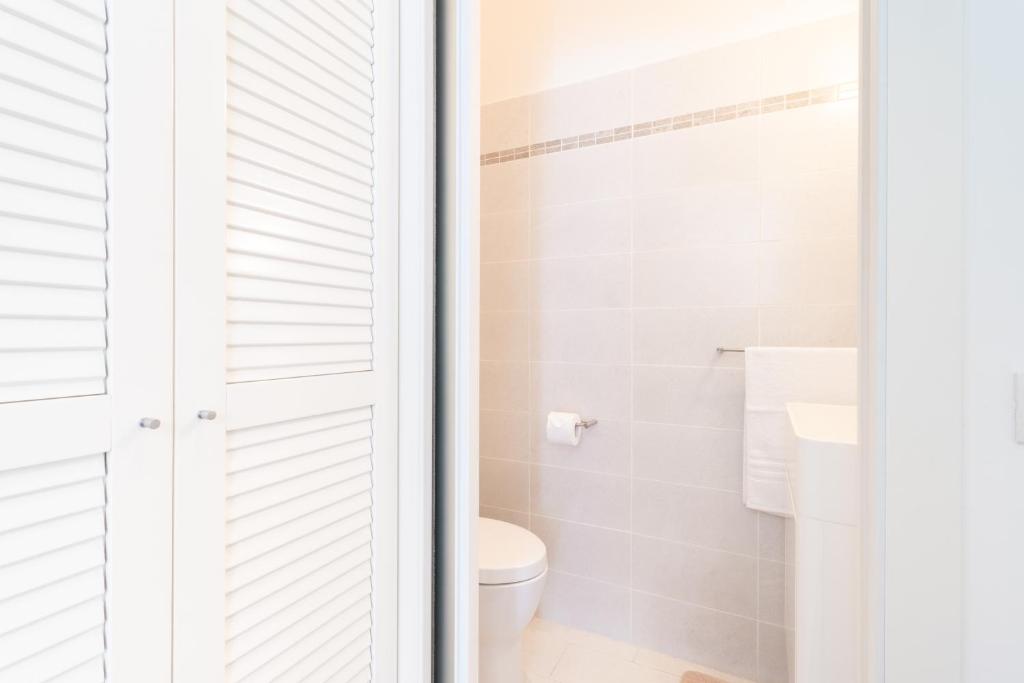 a white bathroom with a toilet and a shower at Dream Suite in Como in Como